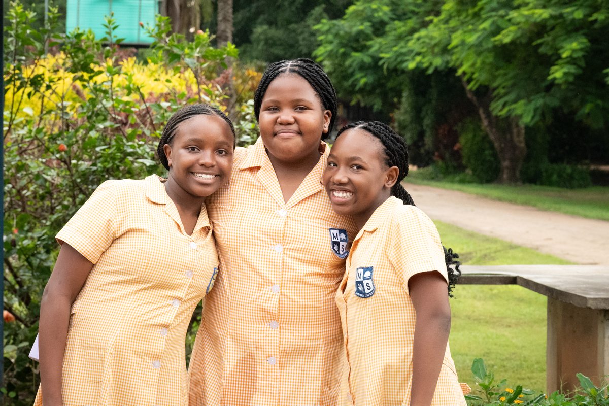 Three senior phase pupils in the school grounds